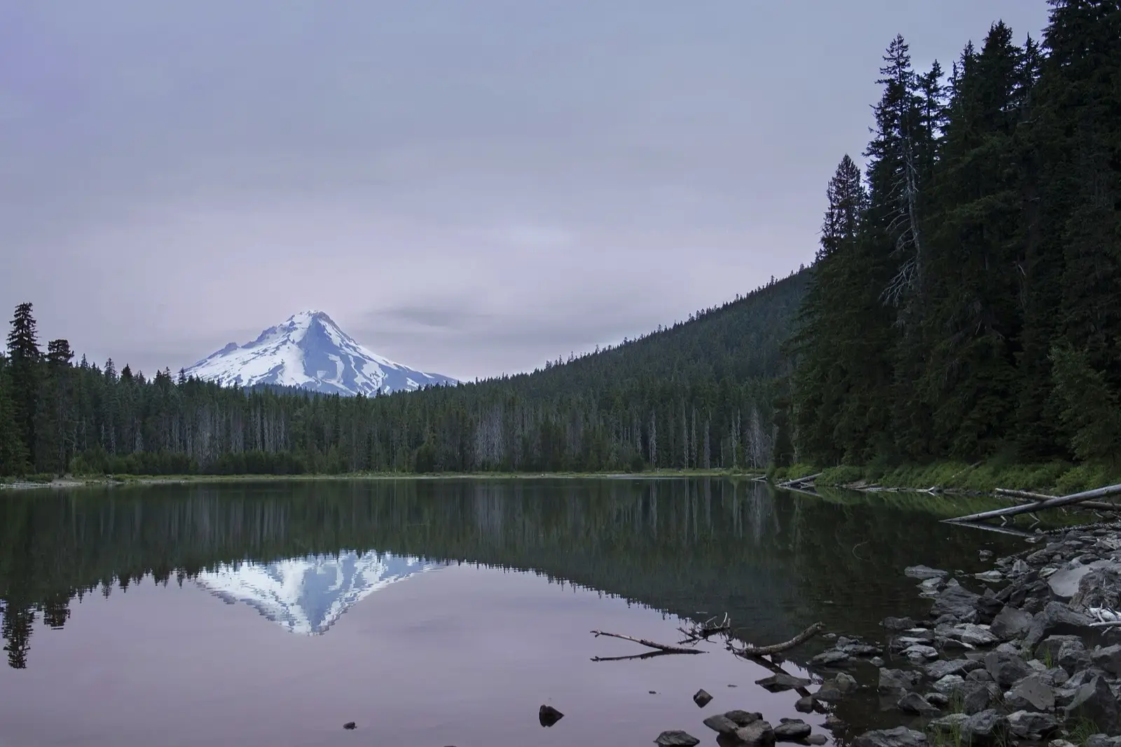 A still mountain lake under a wide sky